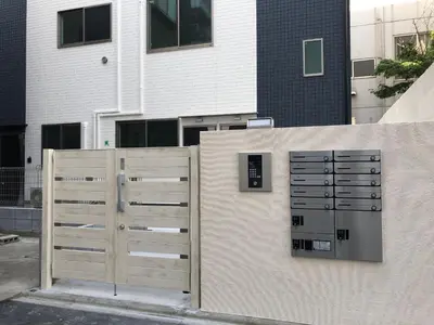two wooden doors on a wall next to a building at FL Residence Takadanobaba in Tokyo