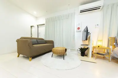 a living room with a couch and a chair at FL Residence Takadanobaba in Tokyo