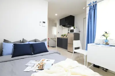 a small bedroom with a bed and a kitchen at FL Residence Takadanobaba in Tokyo