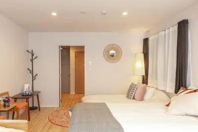 a bedroom with two beds and a table at SAKURA INN Asakusa station walking 4 Min Shinjuku Shibuya Ginza Oshiage in Tokyo