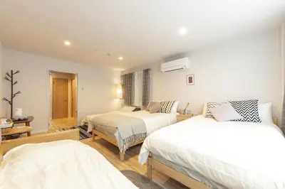 two beds in a room with white walls at SAKURA INN Asakusa station walking 4 Min Shinjuku Shibuya Ginza Oshiage in Tokyo