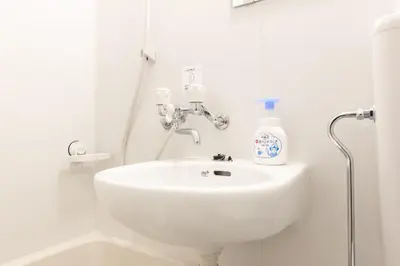 a white bathroom with a sink and a shower at SAKURA INN Asakusa station walking 4 Min Shinjuku Shibuya Ginza Oshiage in Tokyo