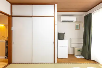 a sliding glass door in a room with a refrigerator at SAKURA INN Asakusa station walking 4 Min Shinjuku Shibuya Ginza Oshiage in Tokyo