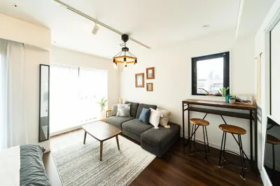 a living room with a couch and a table at GIVE Higashi Nakano in Tokyo