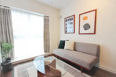 a living room with a couch and a glass table at GIVE Higashi Nakano in Tokyo
