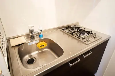 a kitchen counter with a sink and a stove at GIVE Higashi Nakano in Tokyo