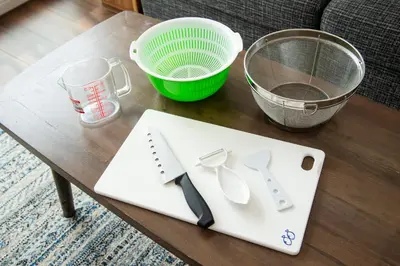 a table with a cutting board and a strainer at GIVE Higashi Nakano in Tokyo