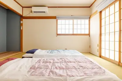 a bedroom with two beds and two windows at \u6c60\u888b\u99c5\u307e\u3067\u5f92\u6b6915\u5206 \u7573\u306e\u5bb6 in Tokyo