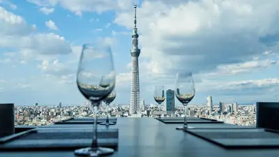 four wine glasses on a table with a view of the eiffel tower at Tobu Hotel Levant Tokyo in Tokyo