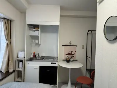 a small kitchen with a sink and a table in a room at Fact Dream House \u65b0\u5bbf\u4e09\u4e01\u76ee\u5f92\u6b693\u5206\u8272\u3005\u63c3\u3046\u30ef\u30f3\u30eb\u30fc\u30e0 in Tokyo