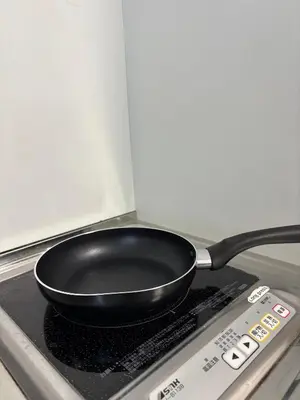 a black frying pan sitting on top of a stove at Fact Dream House \u65b0\u5bbf\u4e09\u4e01\u76ee\u5f92\u6b693\u5206\u8272\u3005\u63c3\u3046\u30ef\u30f3\u30eb\u30fc\u30e0 in Tokyo