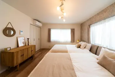 a bedroom with two beds and a couch at GIVE Araiyakushi in Tokyo