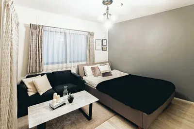 a small bedroom with a bed and a couch at GIVE Araiyakushi in Tokyo
