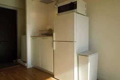 a white refrigerator with a microwave on top of it at Dwell Urban 6C in Tokyo