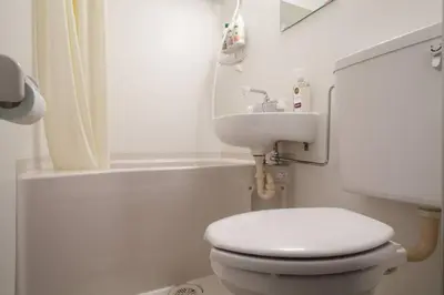 a white bathroom with a toilet and a sink at Dwell Urban 6C in Tokyo