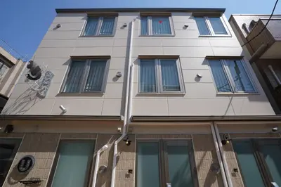 a tall white building with many windows at U-Hotel Takadanobaba in Tokyo