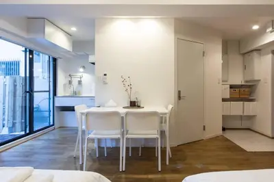 a dining room with a white table and white chairs at Dwell Urban 2B in Tokyo