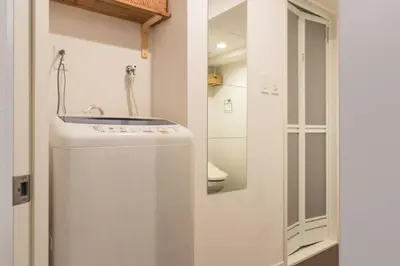 a white refrigerator in a bathroom with a mirror at Dwell Urban 2B in Tokyo