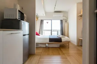 a small room with a bed and a kitchen at Dwell Urban 7C in Tokyo