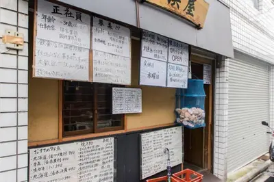 a restaurant with signs on the side of a building at Dwell Urban 7C in Tokyo