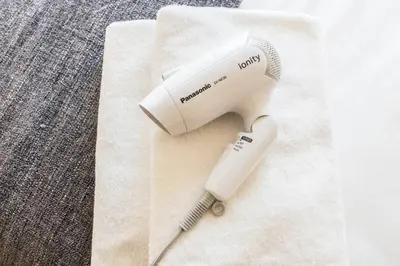a white hair dryer sitting on top of a towel at Dwell Urban 7C in Tokyo