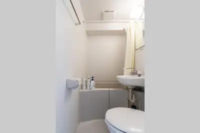 a small bathroom with a toilet and a sink at Dwell Urban 7C in Tokyo