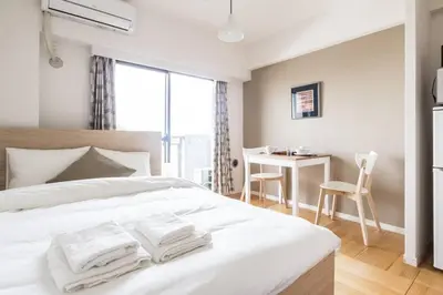 a bedroom with a white bed with towels on it at Dwell Urban 7D in Tokyo