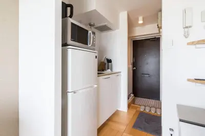 a kitchen with a refrigerator and a microwave at Dwell Urban 7D in Tokyo