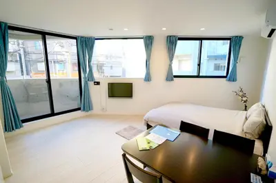 a bedroom with a bed and a desk and a table at Court Residence Tokyo Nakano in Tokyo