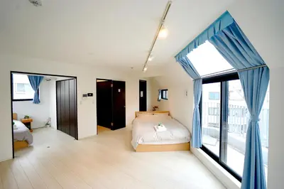 a bedroom with a bed and a large window at Court Residence Tokyo Nakano in Tokyo