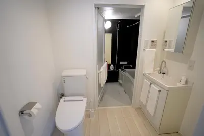 a white bathroom with a toilet and a sink at Court Residence Tokyo Nakano in Tokyo