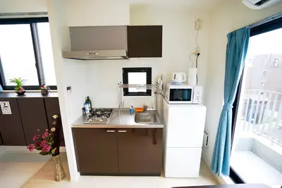 a small kitchen with a refrigerator and a microwave at Court Residence Tokyo Nakano in Tokyo