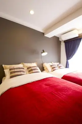 a bedroom with two beds with red blanket at Akasaka Koyu Building 801 in Tokyo
