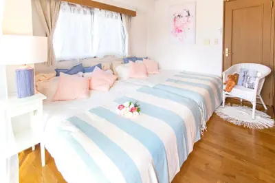 a bedroom with two beds with pink and blue sheets at HARMONIA\u6771\u4eac\u5800\u5207 10\u540d\u5b9a\u54e190\u5e73\u7c73\u306e\u5e83\u3044Condominium in Tokyo