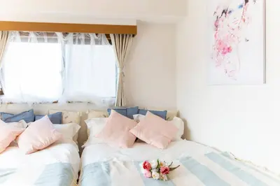 two beds in a room with flowers on them at HARMONIA\u6771\u4eac\u5800\u5207 10\u540d\u5b9a\u54e190\u5e73\u7c73\u306e\u5e83\u3044Condominium in Tokyo