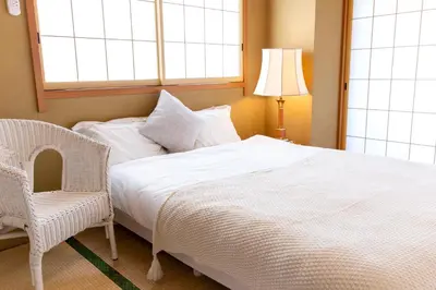 a bedroom with a bed and a chair and a window at HARMONIA\u6771\u4eac\u5800\u5207 10\u540d\u5b9a\u54e190\u5e73\u7c73\u306e\u5e83\u3044Condominium in Tokyo