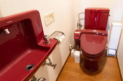 a bathroom with a red toilet and a sink at HARMONIA\u6771\u4eac\u5800\u5207 10\u540d\u5b9a\u54e190\u5e73\u7c73\u306e\u5e83\u3044Condominium in Tokyo
