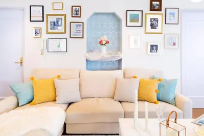 a living room with a couch and a wall of pictures at HARMONIA\u6771\u4eac\u5800\u5207 10\u540d\u5b9a\u54e190\u5e73\u7c73\u306e\u5e83\u3044Condominium in Tokyo