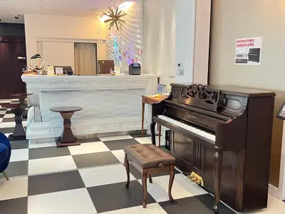 a living room with a piano and a stool at Centurion Hotel Residential Akasaka Station in Tokyo