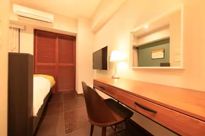 a bedroom with a desk with a bed and a mirror at Centurion Hotel Residential Akasaka Station in Tokyo