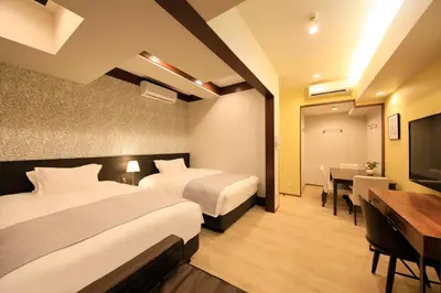 a hotel room with two beds and a table and a desk at Centurion Hotel Residential Akasaka Station in Tokyo