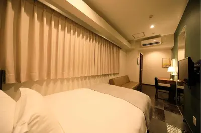 a bedroom with a bed and a desk and a television at Centurion Hotel Residential Akasaka Station in Tokyo