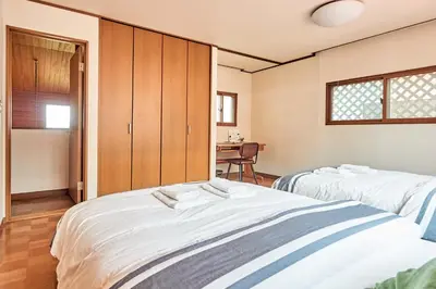 two beds in a room with a table at Villa Shibuya in Tokyo