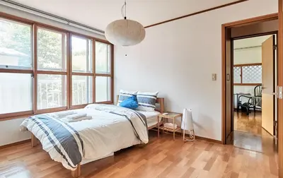 a bedroom with a bed in a room with windows at Villa Shibuya in Tokyo