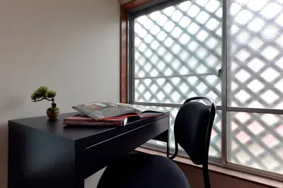 a desk with a book and a chair in front of a window at Annex Shibuya in Tokyo