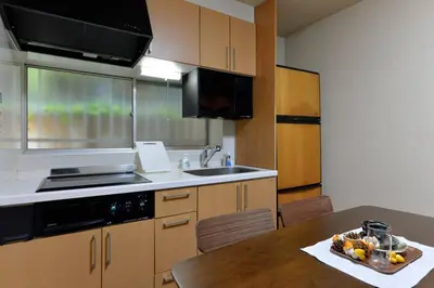 a kitchen with a table and a sink and a counter top at Annex Shibuya in Tokyo