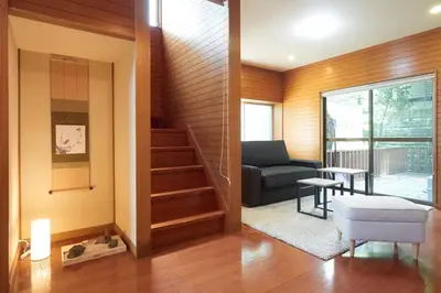 a living room with a couch and a stairway at Annex Shibuya in Tokyo