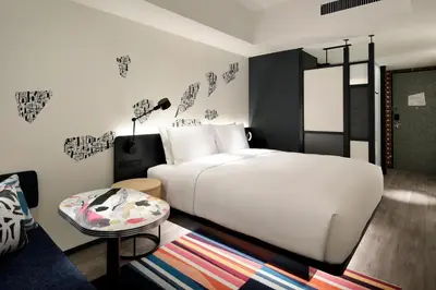 a bedroom with a white bed and a table at Aloft Tokyo Ginza in Tokyo