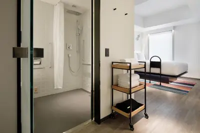 a bathroom with a shower and a bed in a room at Aloft Tokyo Ginza in Tokyo