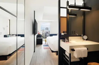 a bathroom with a sink and a bedroom at Aloft Tokyo Ginza in Tokyo